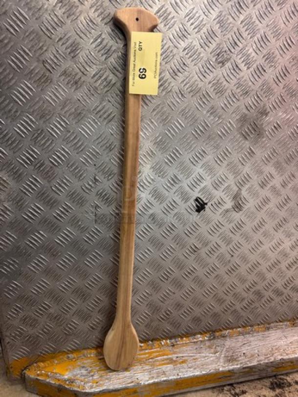 Long wooden paddle cooking utensil with ergonomic handle and a smooth finish. Price tag indicates $9.
