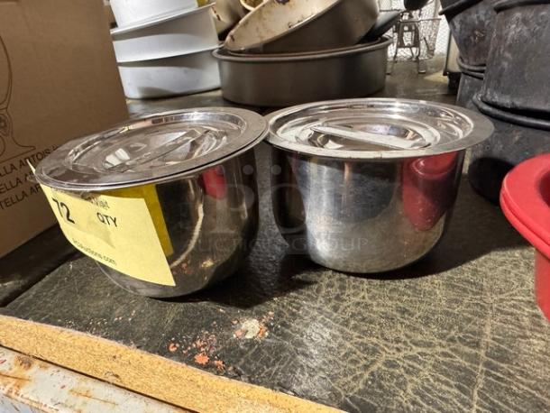 Two stainless steel containers BIDX2, as shown on a shelf. Each has a fitted lid. Slight wear visible on surfaces.