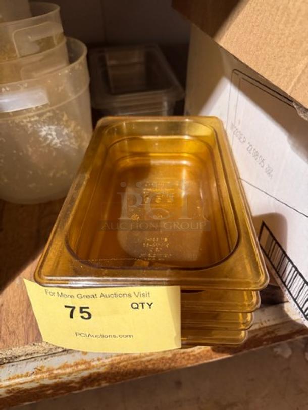 Stack of 1/4x2.5IN BIDX4 food pans, amber color, nested, quantity tag number 75 visible, in good condition.