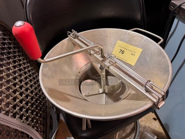 Stainless steel food mill with red handle, in used condition. Auction label indicates item number 76.