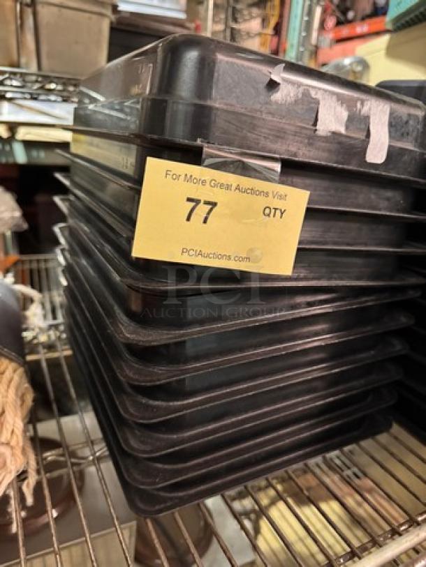 Stack of black plastic food pans, 1/2x2.5IN size, model BIDX10, new condition, label shows quantity '77'.