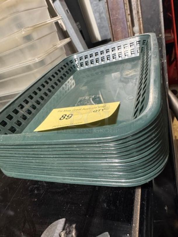 Stack of 14 green rectangular food baskets. Auction tag labeled "89". Sturdy plastic material, uniform design, good condition.