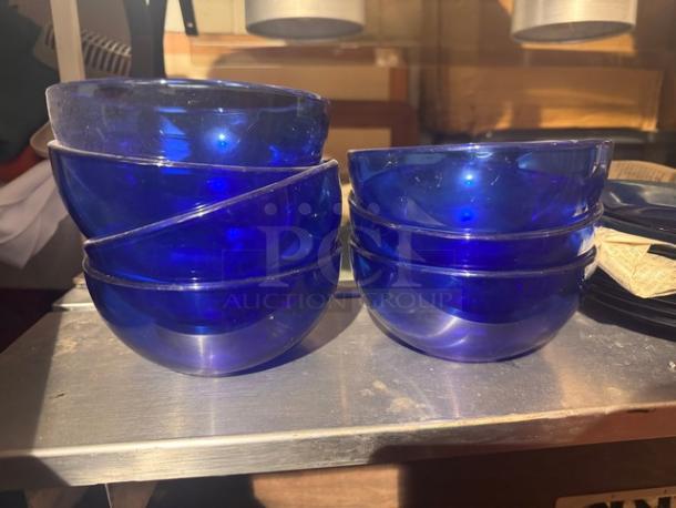 Lot of blue glass cereal bowls and plates, stacked neatly. All pieces included in one money. Good condition.