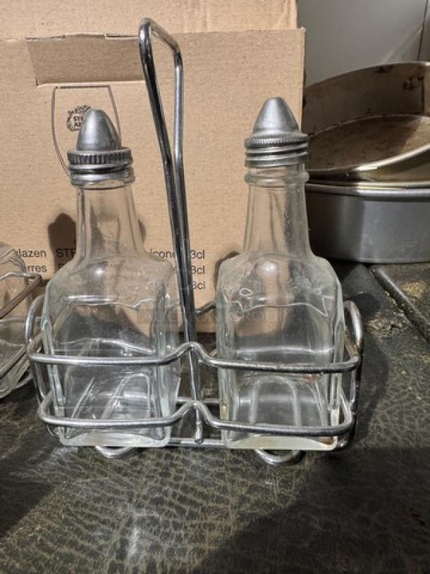 3-piece oil & vinegar cruet set with metal rack; clear glass bottles, metal caps, used condition.