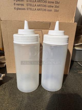 Two translucent squeeze bottles with white caps, used condition, labeled BIDX2.