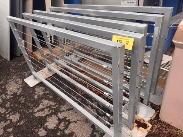 Metal cable railing panels, sturdy construction, used condition with some rust. Label indicates item BIDX5, quantity 4.