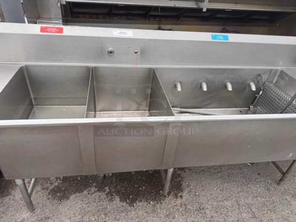 140" 4 bay stainless steel commercial sink. Features four compartments and attached faucet system. Ideal for high-capacity use.