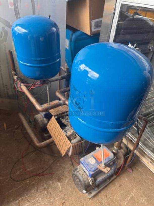 Blue HYDRO-PNEUMATIC PUMP TANK, Model V15P 100, mounted on a metal frame. Visible valves and wiring. Used condition.