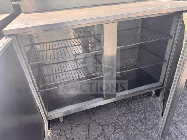 DUKE RUF-48 48" undercounter refrigerator, stainless steel, dual-door, wire shelving, good condition, outdoor setting.
