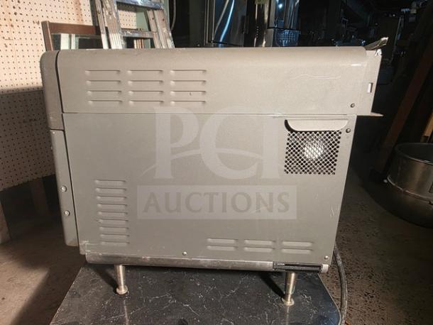 Turbochef NGO countertop oven, gray exterior, model NGO, used condition, vented side panel, mounted on metal legs.
