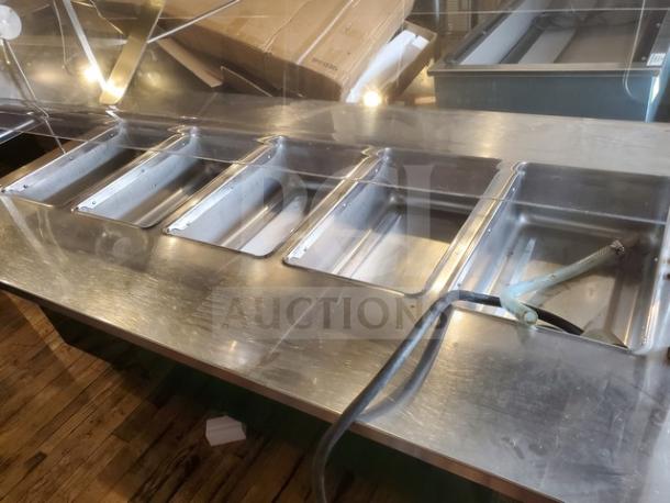 Colorpoint 5 bay steam table, 120V. Features stainless steel construction, in good condition, multiple compartments, visible drainage hose.