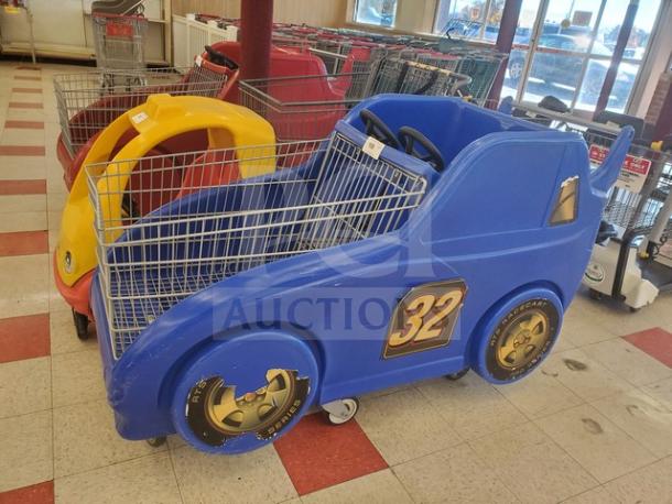 Blue car-shaped shopping cart with number 32 on the side, featuring a child seating area. Visible wear on wheels.