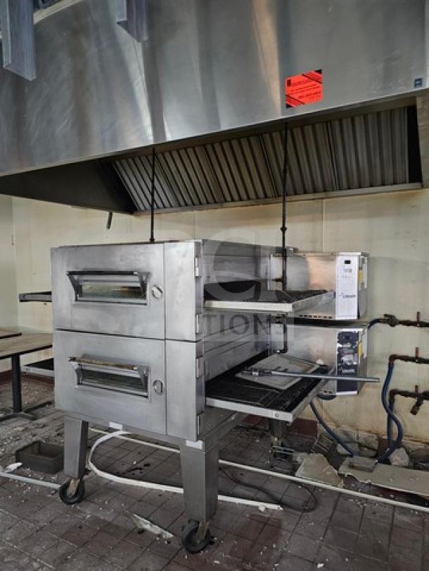 Lincoln Impinger single stack conveyor oven, stainless steel, dual doors, mounted on wheels, industrial kitchen setting.