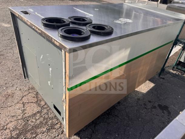 Commercial metal and wood stand with a stainless steel top, featuring four cup dispensers. Moderate wear visible on surfaces.