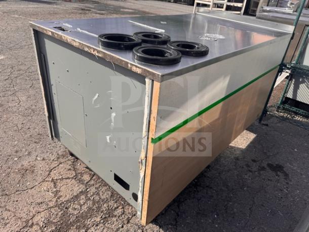 Commercial metal stand with four circular holders, wood panel side, and visible signs of wear and tear. Ideal for industrial use.