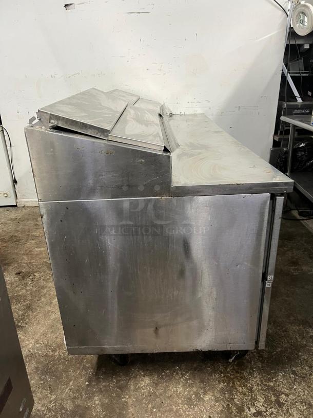 Randall 8383N pizza prep table with 4 drawers, 1 door, stainless steel, used condition, caster wheels, side view.