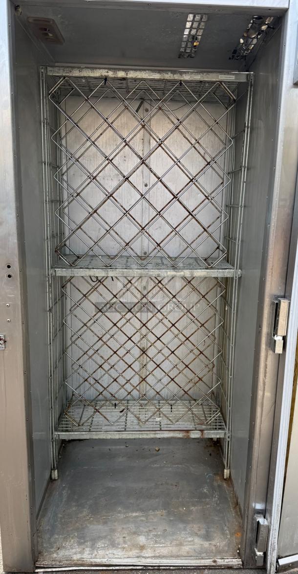 TRAULSEN ART 1-32W 36" stainless steel roll-in refrigerator, solid door, shelving inside, used condition, visible signs of wear.