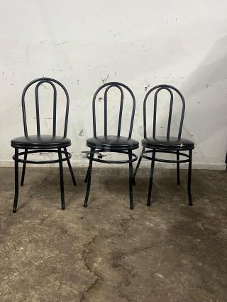 Set of three cafe dining chairs with black frames and padded vinyl seats. Good condition, suitable for restaurant use.