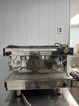 FAEMA E98 RE espresso machine in excellent condition, featuring dual group heads, stainless steel finish, and user-friendly controls.
