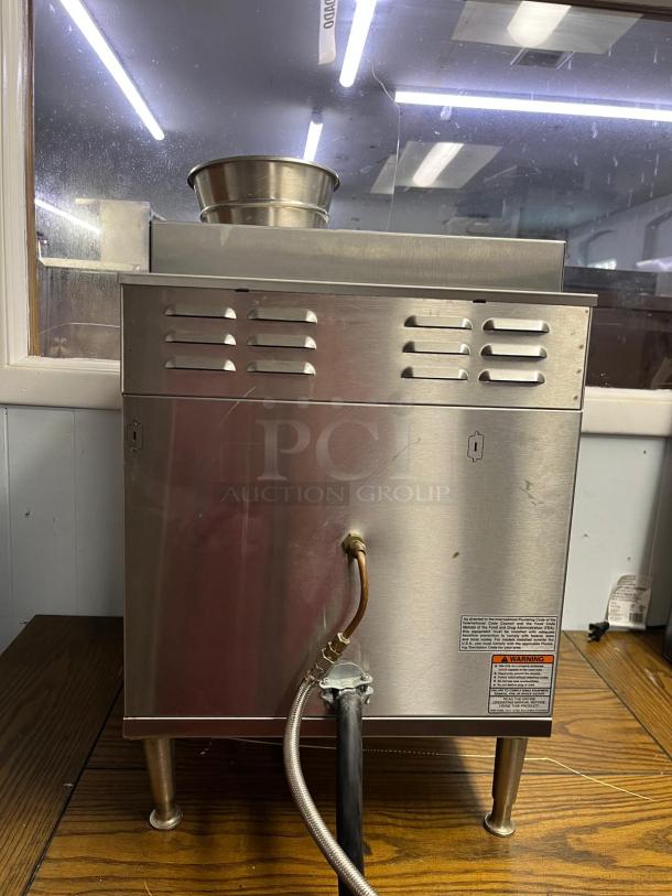 BUNN AXIOM coffee brewer with stainless steel body, two upper and two lower warmers. Visible wiring and warning label.