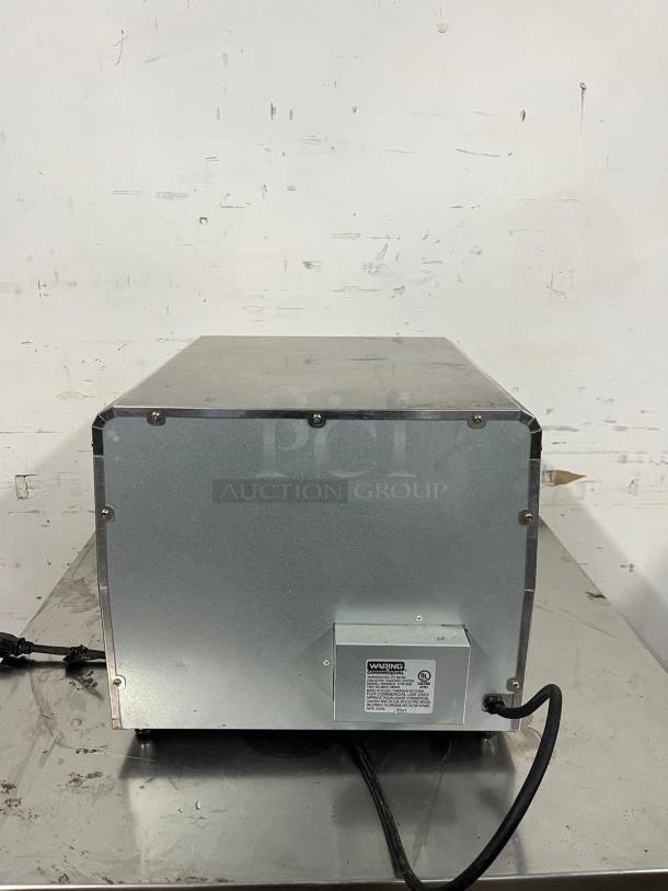 Waring CTS1000 Conveyor Toaster, 450 slices/hr, 2" opening, 120v, metal casing, rear view, visible power cord and label.