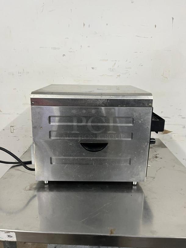 Waring CTS1000 Conveyor Toaster, silver, 450 slices/hr, 2" product opening, 120v, visible power cord, on metal surface.