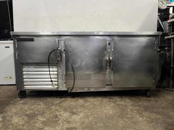 UNIVERSAL COOLER 3 Door Worktop refrigerator, stainless steel, built-in wheels, visible power cord, used condition.