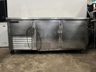 UNIVERSAL COOLER 3 Door Worktop refrigerator, stainless steel, built-in wheels, visible power cord, used condition.