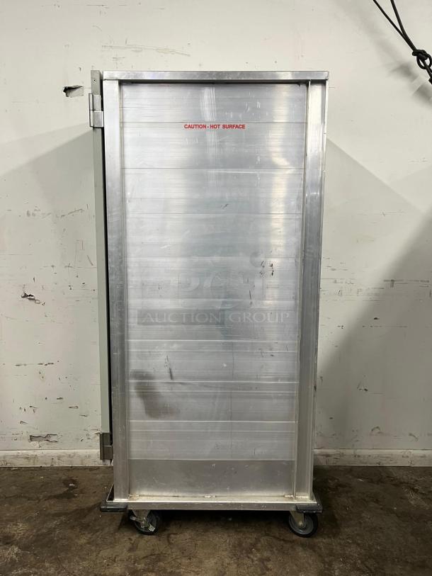Avantco HEAT-1836 heated holding cabinet, full size, insulated, clear door, aluminum finish, on casters, "Caution: Hot Surface" label.