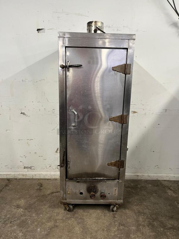 UNIVERSAL Smoker Oven, galvanized interior, 3 burners, 78" height; shows wear, rust on hinges, mounted on casters.