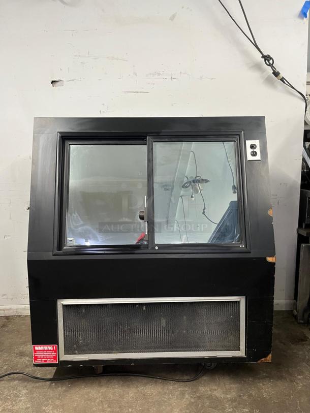 36" curved refrigerated display case, black frame, glass front, ventilation panel, electrical outlet, visible wear.