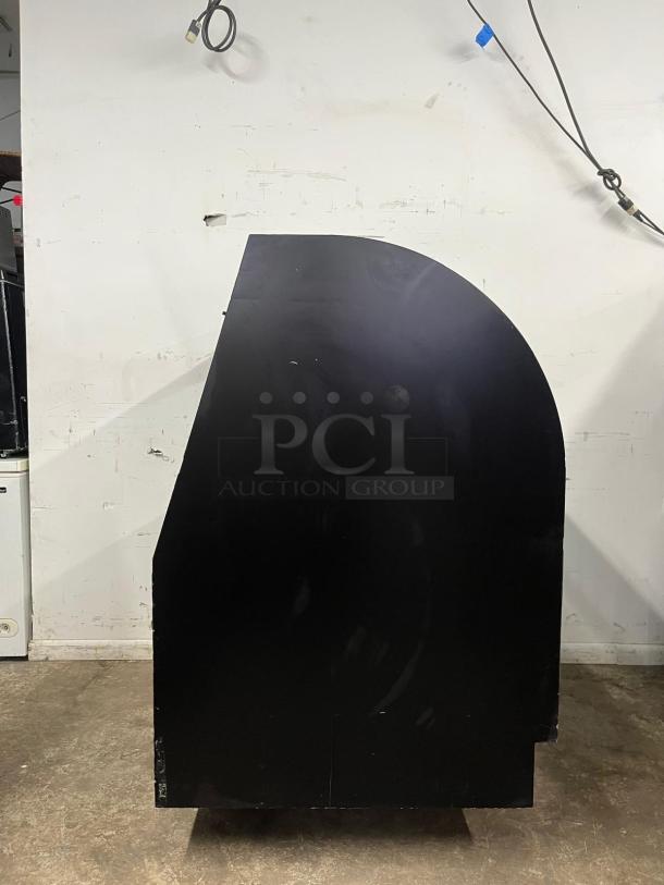 36" curved refrigerated display case, black exterior, used condition. Perfect for showcasing perishable items.