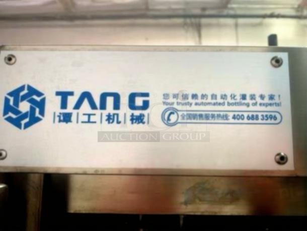 TANG Two-Head Automatic Filling Machine, premium condition, model TAN-L-FIL-0423. Metal plate shows branding and contact info.