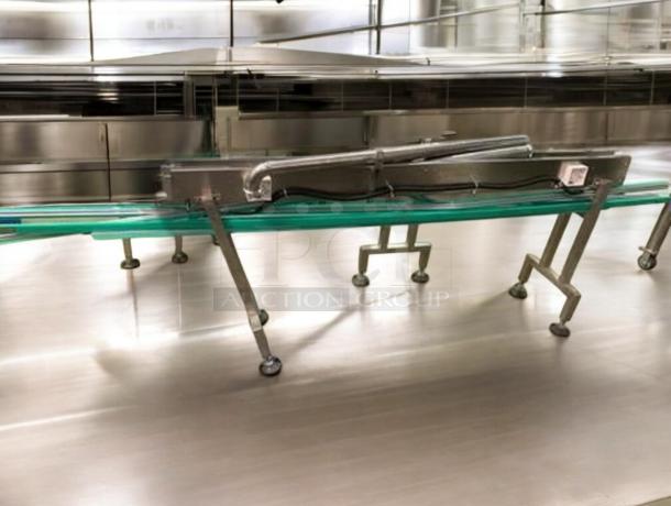 Industrial stainless steel bottle conveyor system with adjustable speed. Fully tested, operational, premium condition. Model: CONV-L-LINE-0427.