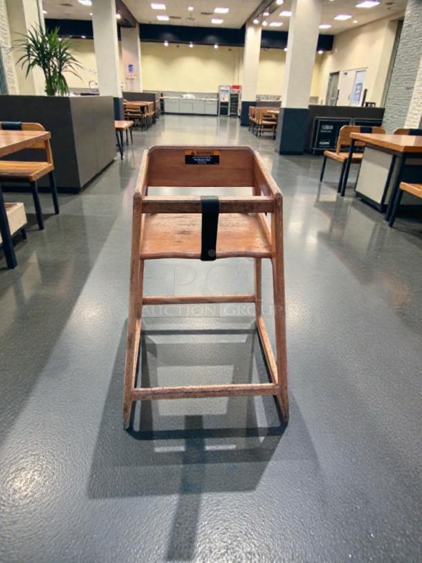 Commercial Grade wooden high chair, model FUR-S-HCHAIR-0580, in prime condition. Features safety harness, perfect for restaurants.