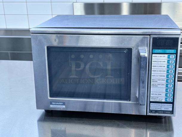 Sharp R-22GT commercial microwave oven, 1200W, stainless steel, superb condition. Features keypad with multiple settings.