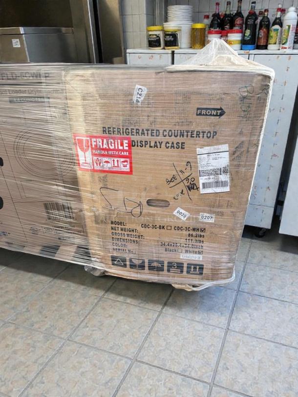 Brand-new KoolMore refrigerated display case, model CDC-3C-BK/WH, in original packaging with handling marks.