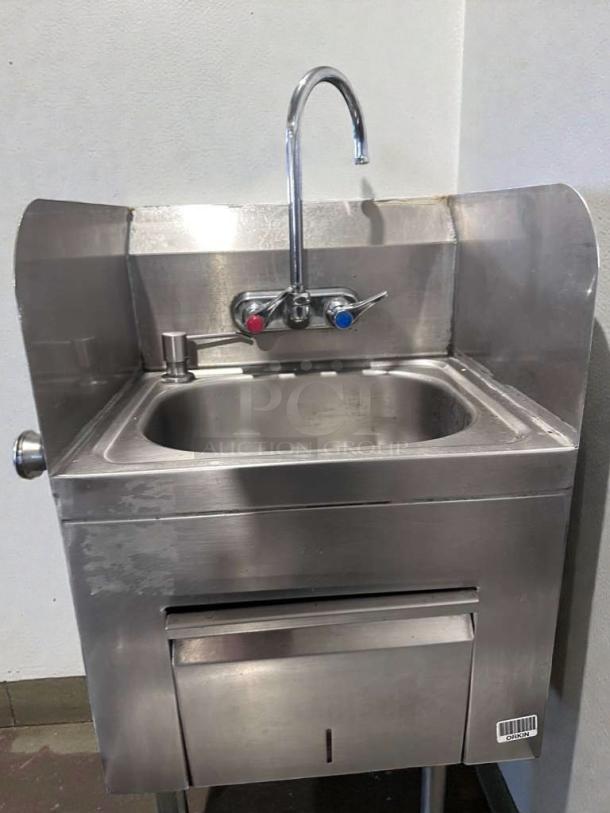 Commercial stainless steel hand wash sink with gooseneck faucet, built-in paper towel dispenser, high-grade condition.