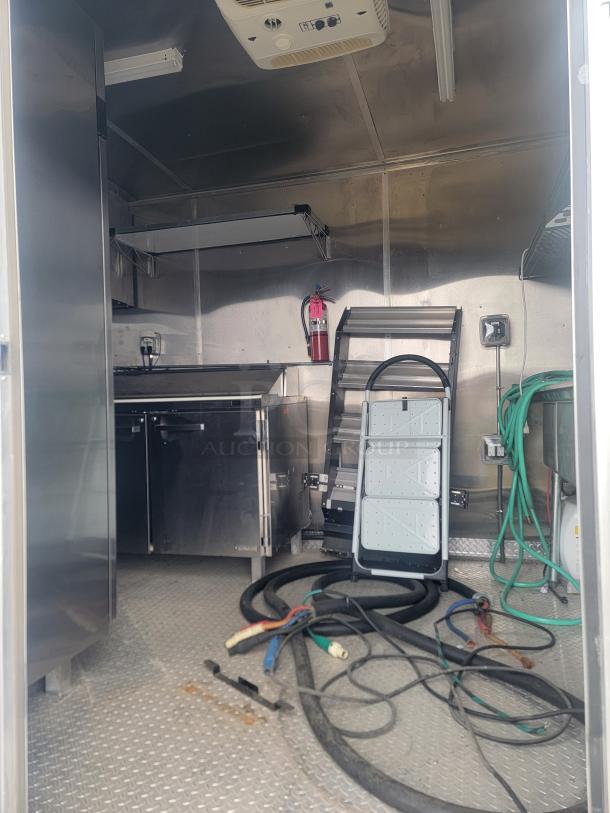 24' Rock Solid Cargo food trailer interior, showing stainless steel surfaces, Arctic Air fridge, and CaptiveAire hood. Needs cleaning.