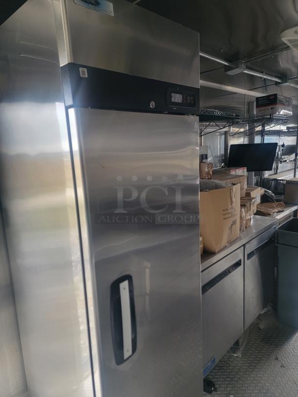 Professional 24' mobile kitchen trailer with Arctic Air fridge and stainless steel counters. Needs cleaning. VIN: 573BE2421MF033749.