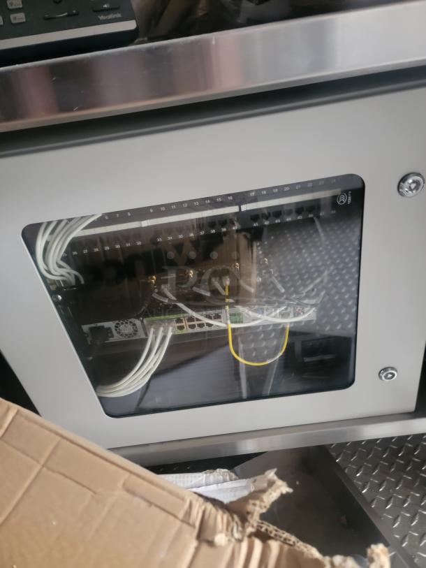 Alt text: Interior of a 24' Rock Solid Cargo mobile kitchen trailer showing wiring setup, metal surfaces, and a cardboard box.