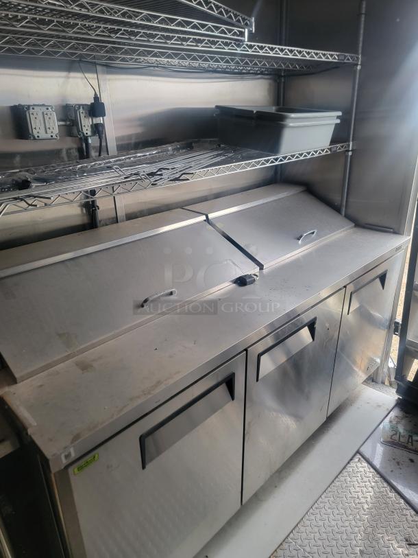 Rock Solid Cargo 24' mobile kitchen interior with stainless steel counters, Arctic Air fridge, and shelving. Needs cleaning.