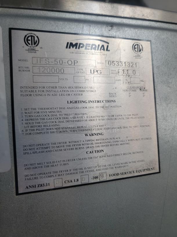 Label on Imperial commercial cooking equipment. Model IFS-50-OP, Serial 05331321, LPG 120,000 BTU/hr rating, safety warnings noted.