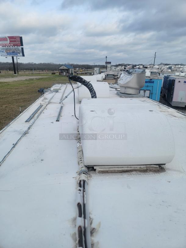 Rooftop of a Rock Solid Cargo 24' mobile kitchen trailer, featuring ventilation components. Dust indicates storage condition.