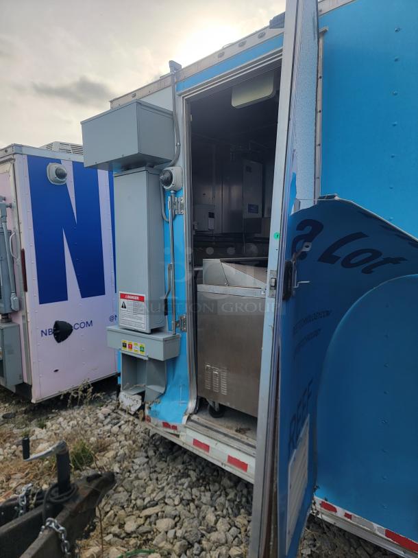 2020 24' Diamond Cargo mobile kitchen in blue, open door view showing stainless steel kitchen equipment and dual-axle chassis.