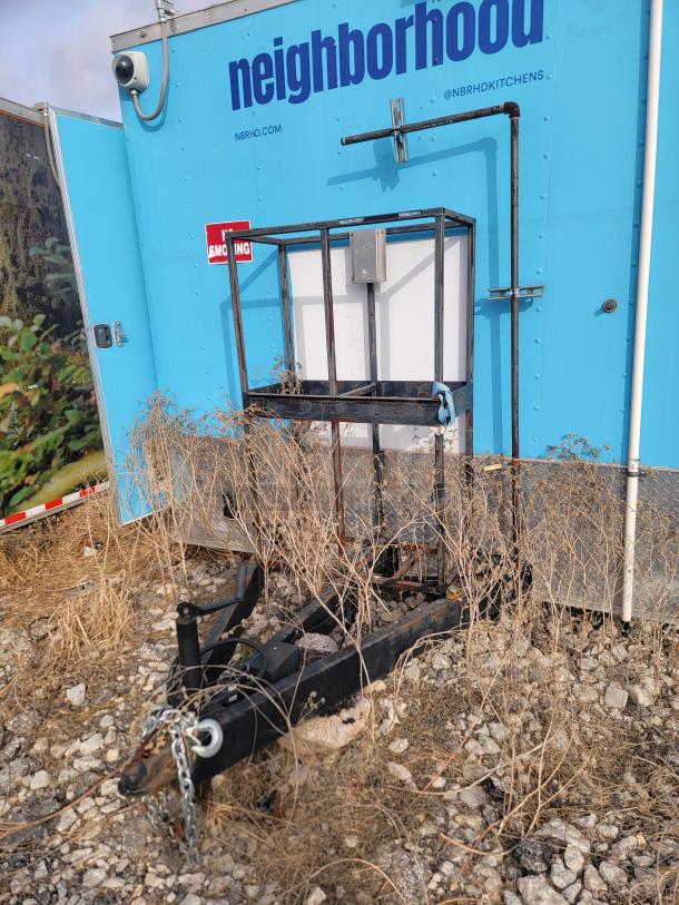 2020 24' Diamond Cargo mobile kitchen trailer with blue exterior, overgrown with weeds. Needs cleaning.