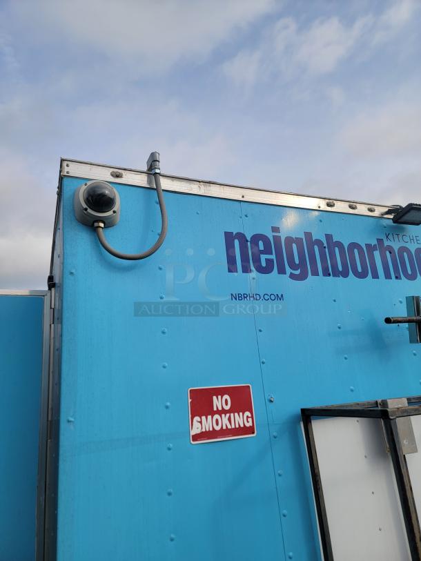 Blue 2020 Diamond Cargo mobile kitchen, security camera, "NO SMOKING" sign, and partially visible web address.