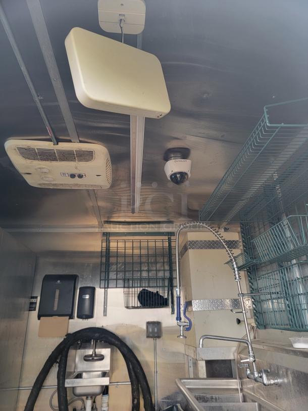 2020 Diamond Cargo 24' mobile kitchen interior with stainless steel wash station, storage racks, and Avigilon security camera.