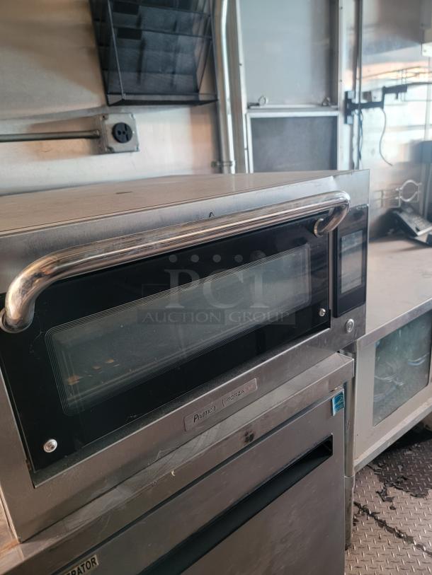 Prática Forza STi high-speed oven inside 2020 24' Diamond Cargo mobile kitchen with stainless steel construction.