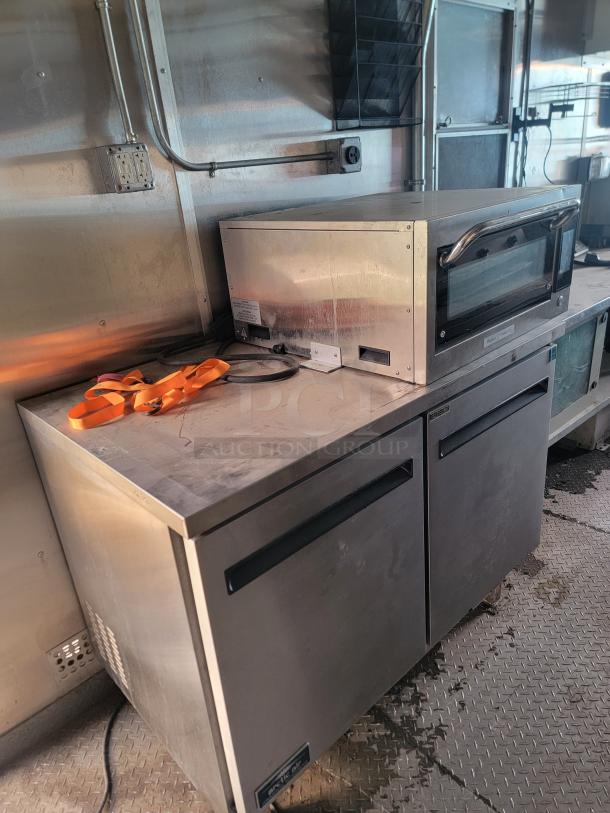 2020 Diamond Cargo mobile kitchen interior, featuring Arctic Air freezer and Prática Forza STi oven; requires cleaning.